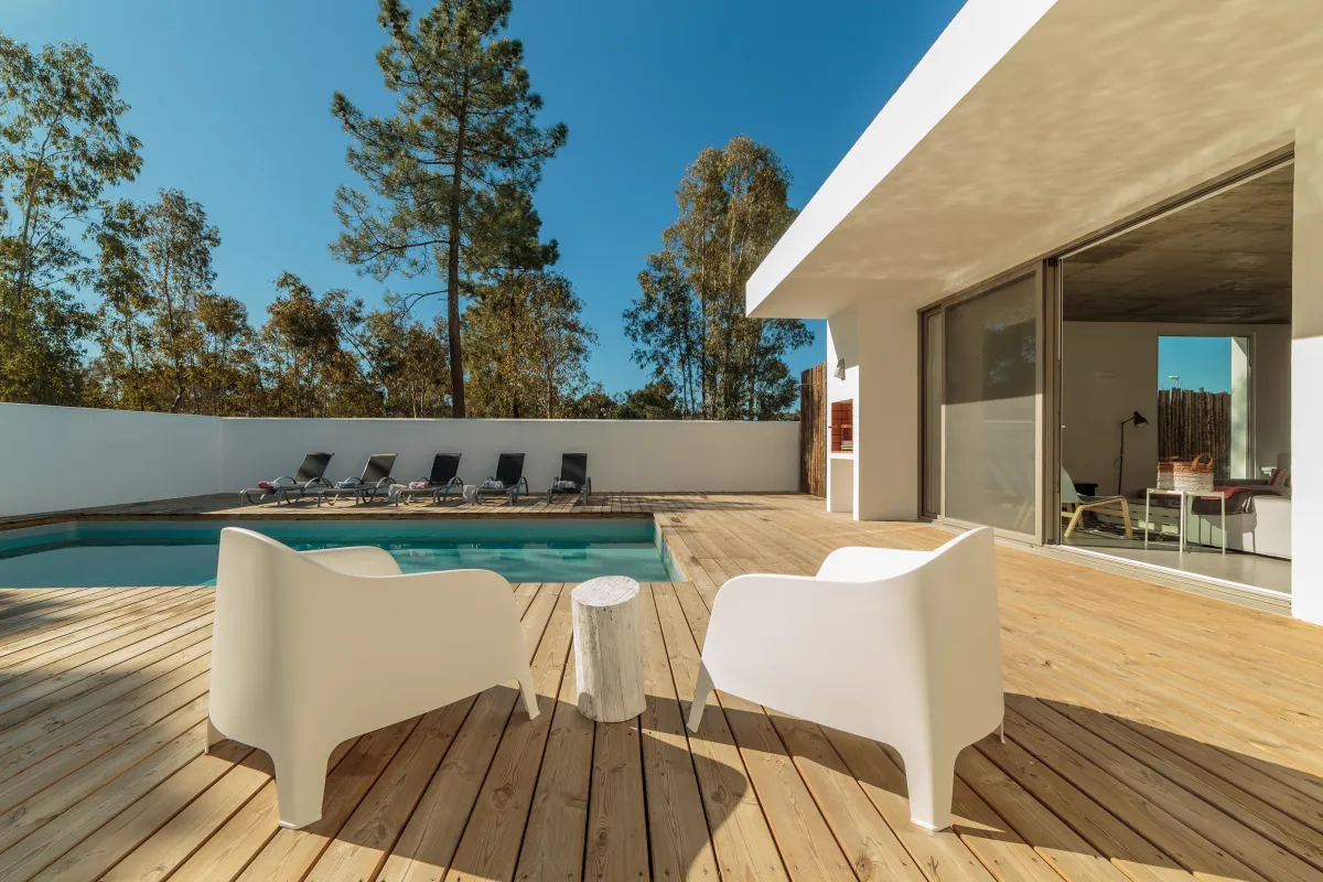 Terrasse en bois et piscine dans un jardin arboré