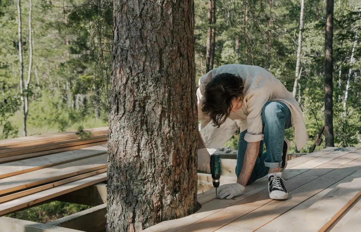 Ouvrier vissant une lame neuve lors de la rénovation d’une terrasse en bois