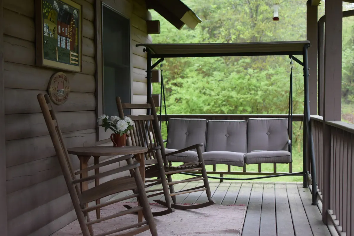 Terrasse en bois couverte, avec fauteuils à bascule et balancelle