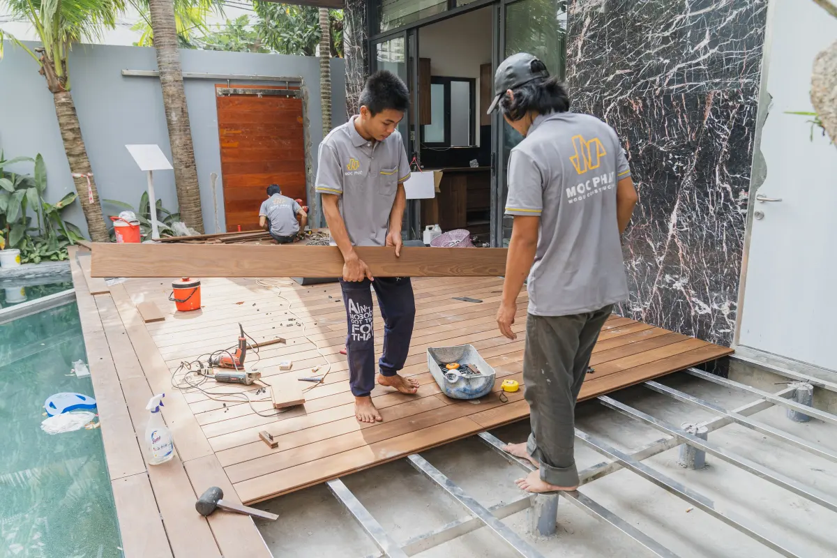 Artisans posant les lames d’une terrasse en bois