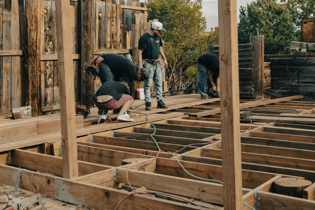 Artisans à genoux sur l’ossature d’une terrasse en bois