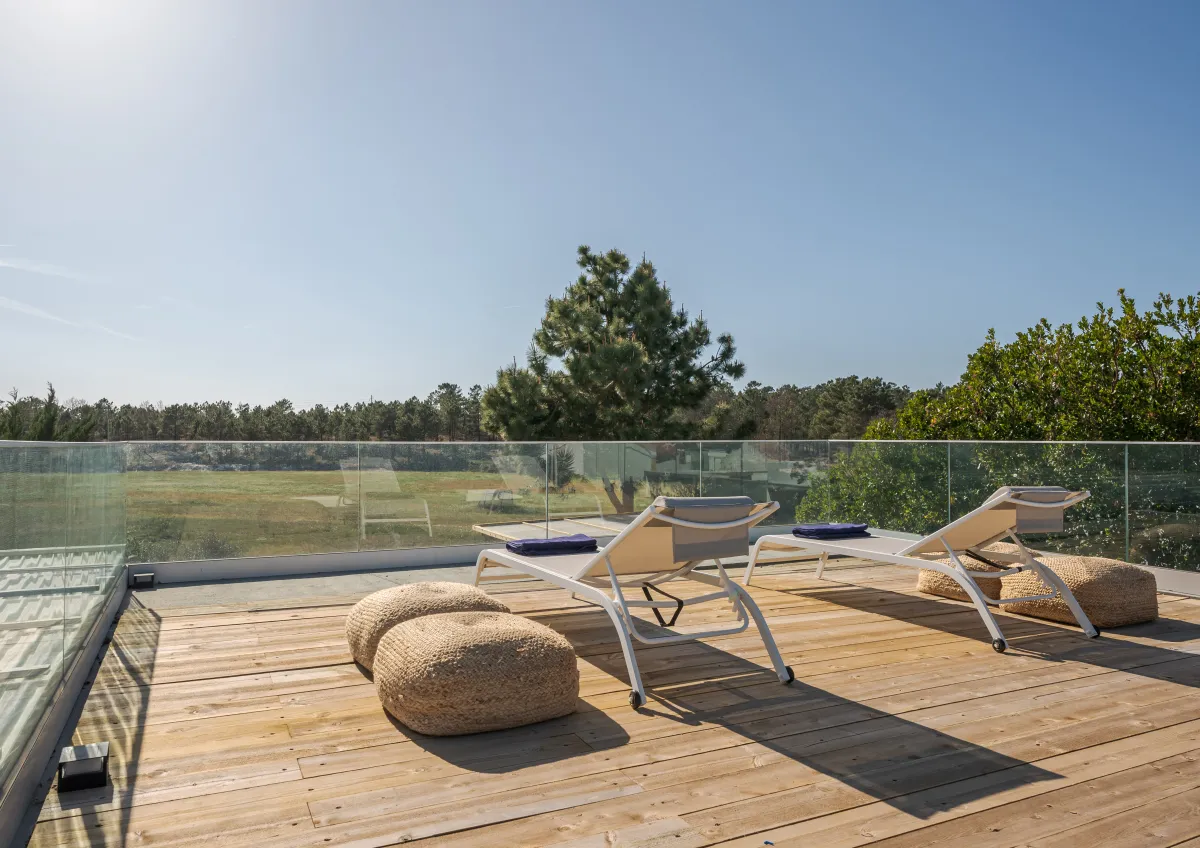 Terrasse en bois avec bains de soleil et vue dégagée sur la végétation